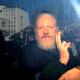 Julian Assange gestures to the media from a police vehicle on his arrival at Westminster Magistrates court on April 11, 2019 in London, England. After weeks of speculation, Wikileaks founder Julian Assange was arrested by Scotland Yard Police Officers inside the Ecuadorian Embassy in Central London this morning. Ecuador’s President, Lenin Moreno, withdrew Assange’s Asylum after seven years citing repeated violations to international conventions.